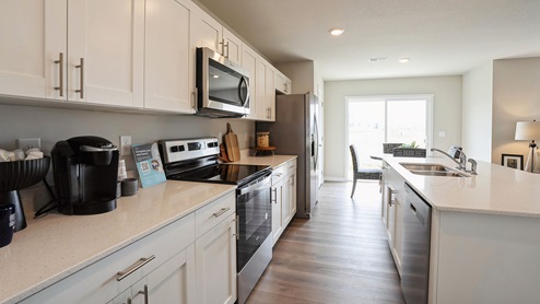 Side view of modern kitchen with stainless-steel appliances and large island