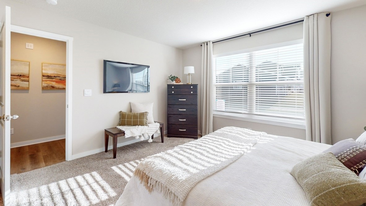 Light filled  primary bedroom showing hallway