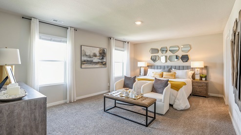 spacious primary bedroom with two windows