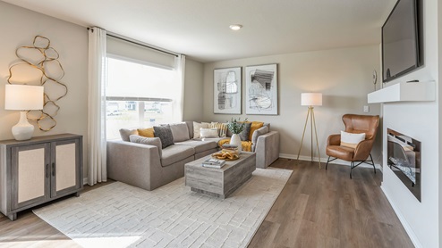 bright living room with large window and grey sectional
