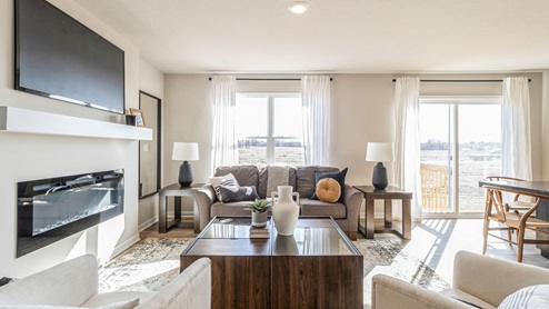 Bright and spacious living room with large window and electric fireplace