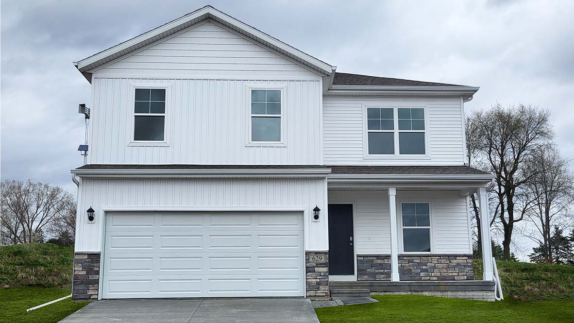 Bellhaven Floor Plan has a stone and siding exterior with a front porch, five windows and a two car garage.