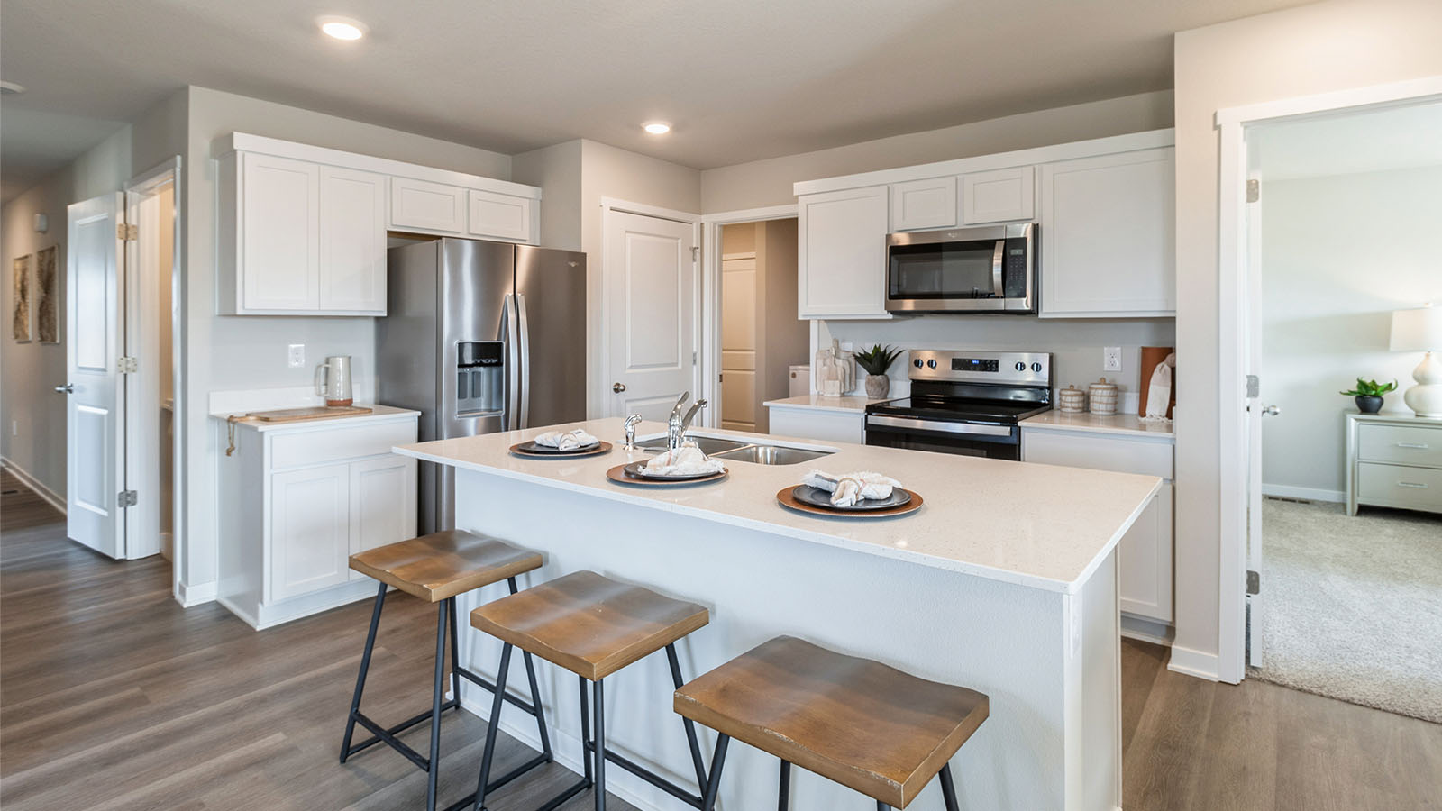 Central kitchen island anchors the home adding a dining option, full sink, pantry and storage, multi-prep zones