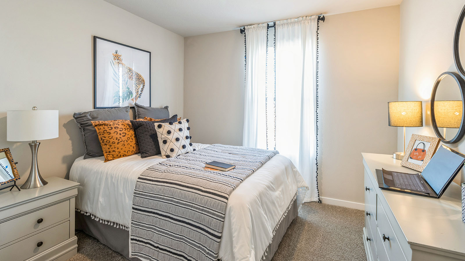 First bedroom with bed and white nightstands and white dresser