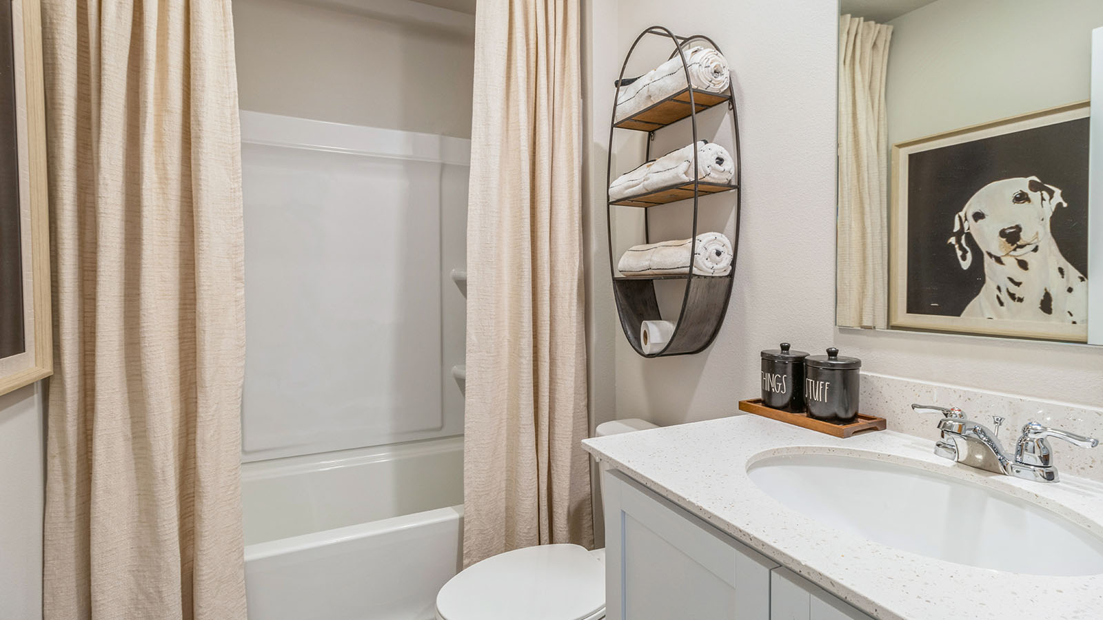 First bathroom with white cabinetry and shower with bathtub