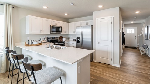 White kitchen with quartz countertops amd stainless-steel appliances