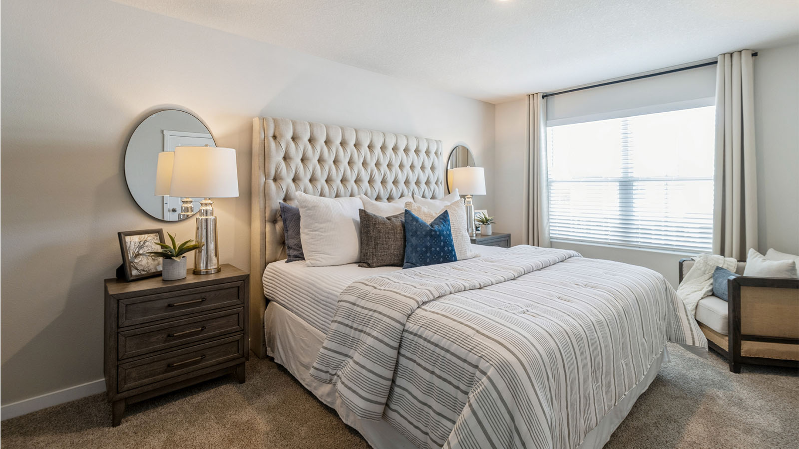 Primary bedroom with large window and bed with wooden nightstands