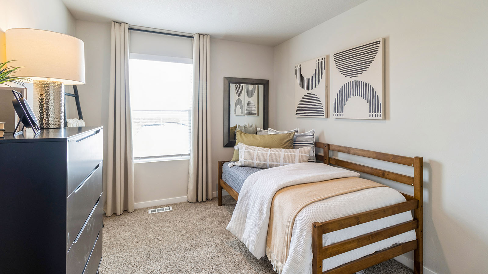 Second bedroom with white twin bed and black dresser