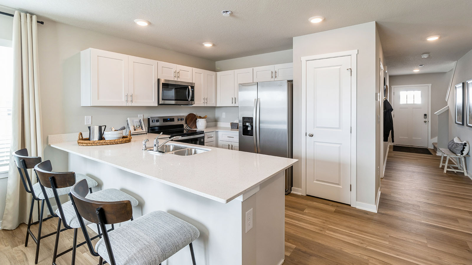White kitchen with quartz countertops and stainless-steel appliances