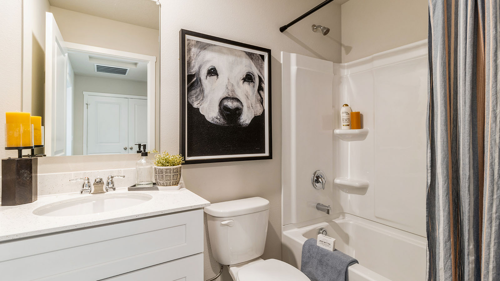 First bathroom with white cabinetry and a shower with bathtub
