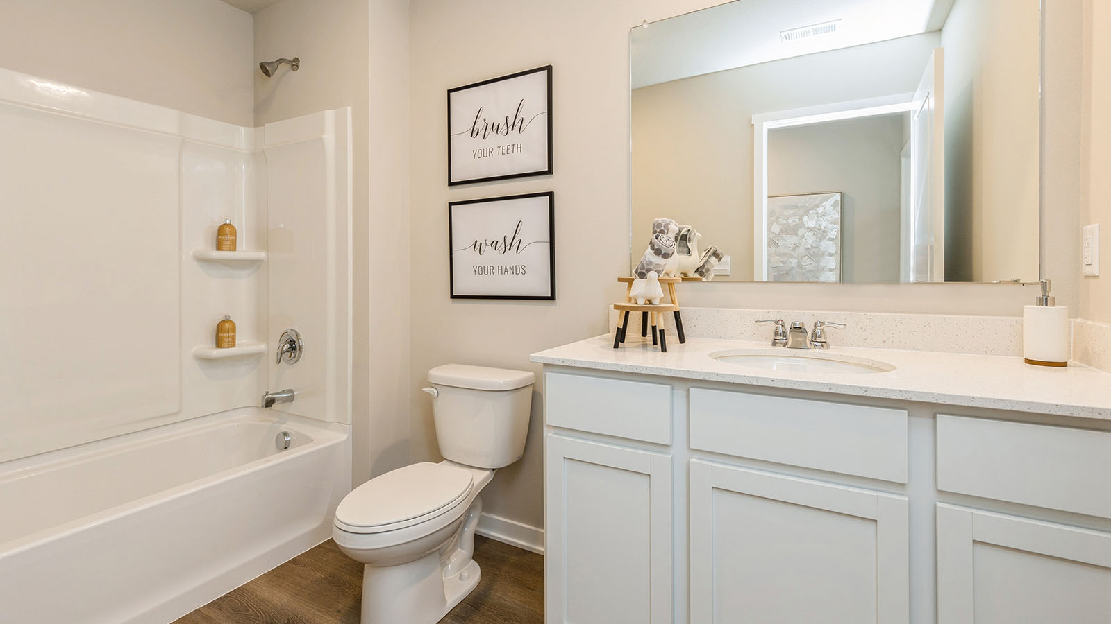 First bathroom with white cabinetry and bathtub