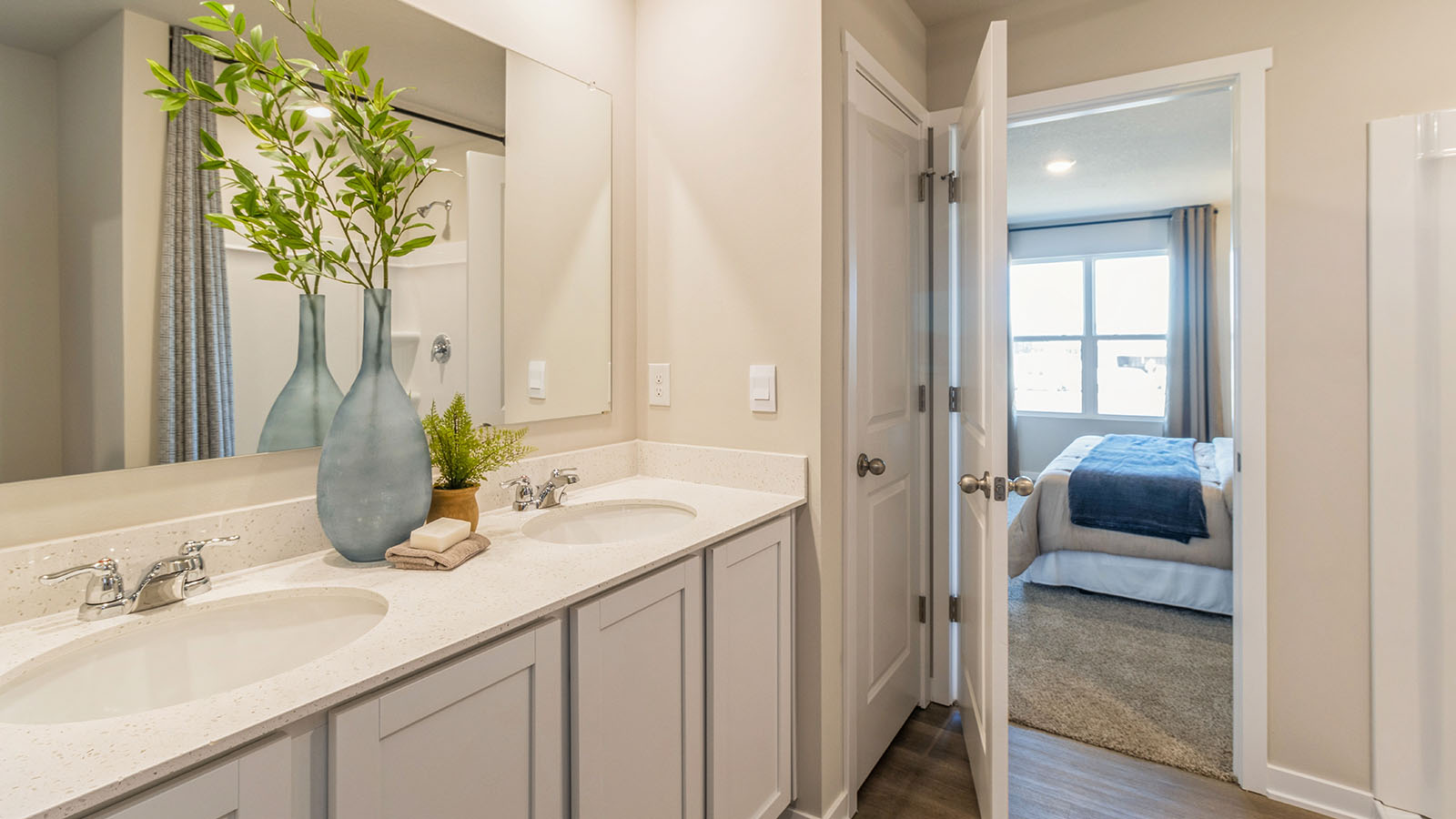 Primary bathroom with the large mirror and white cabinets