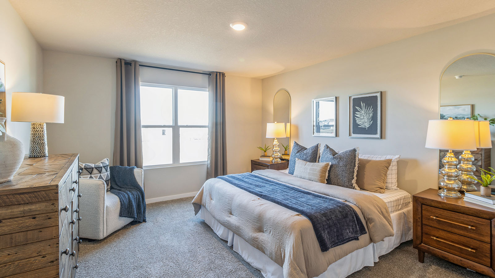 Large primary bedroom with wooden dresser and nightstand