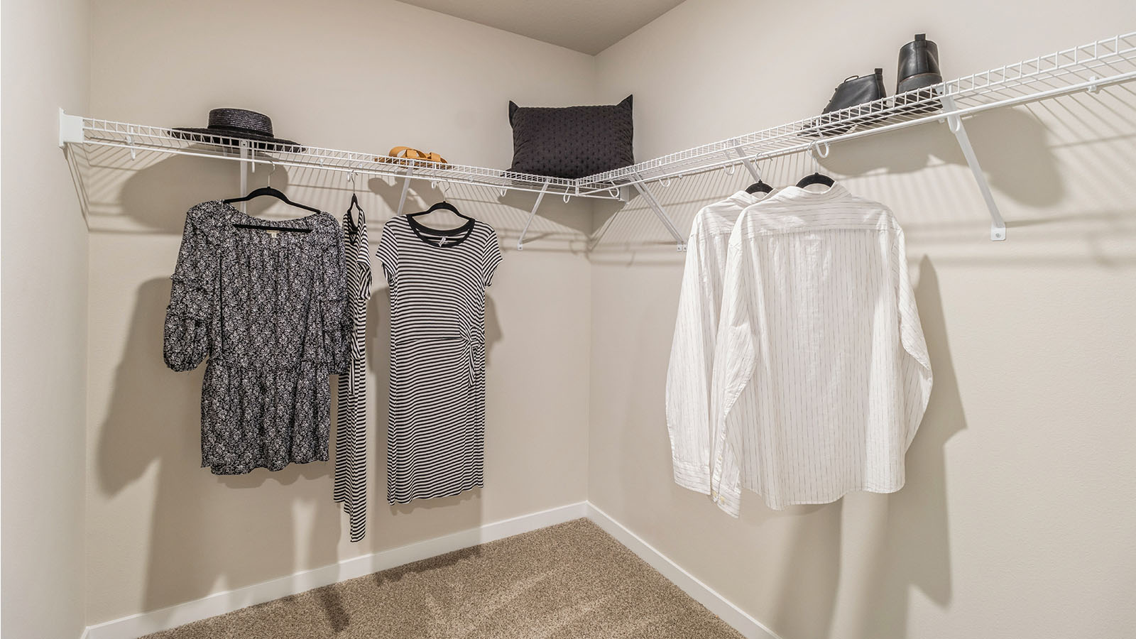 Walk-in closet with built-in shelving located off the owner’s spa-inspired bathroom in Painted Woods West