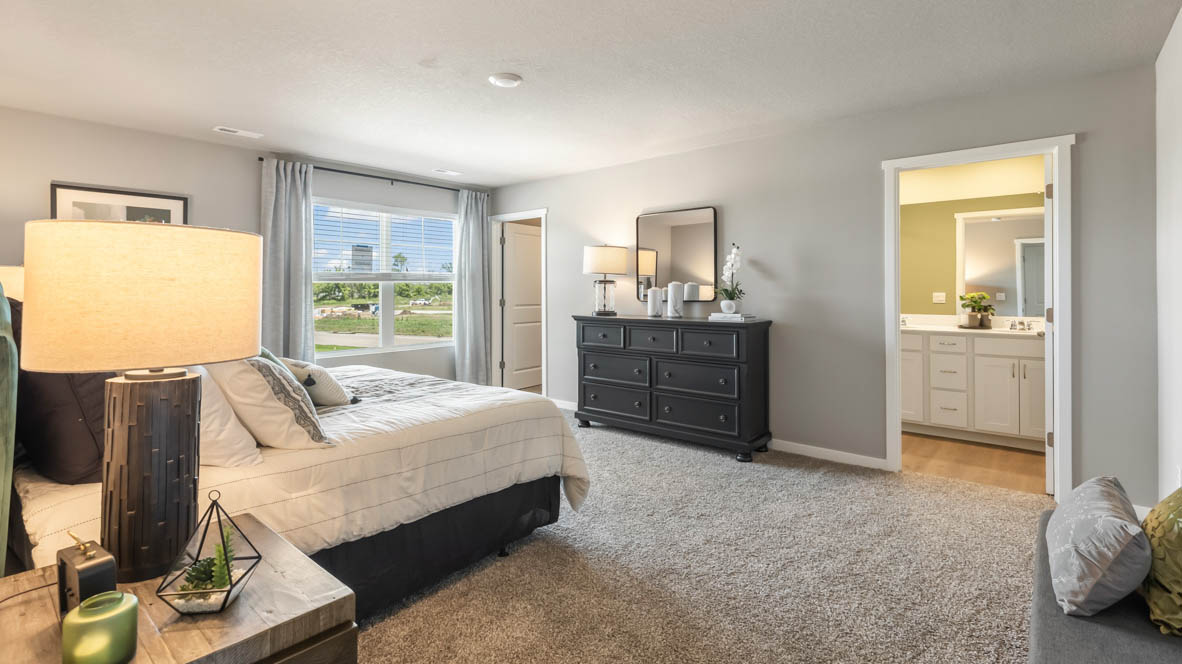 Primary suite by D.R. Horton includes corner window views, details like walk-through access to en suite bathroom, walk-in closet