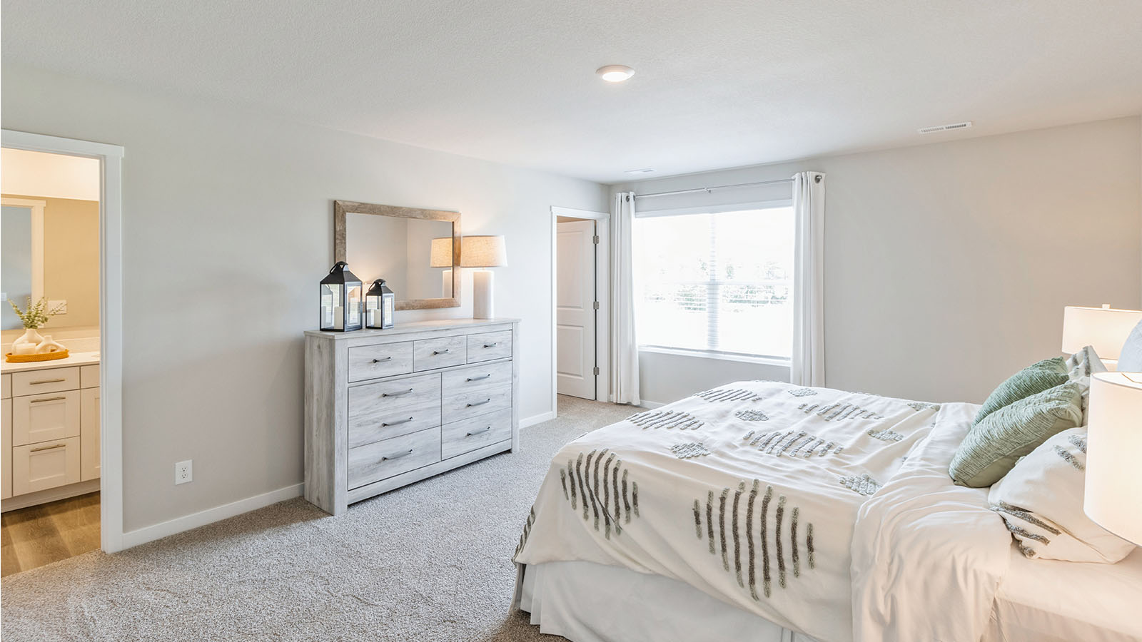 Primary bedroom in this New Townhome features ample space, double windows, soft carpet, a Walk-in Closet, private En-Suite Bath