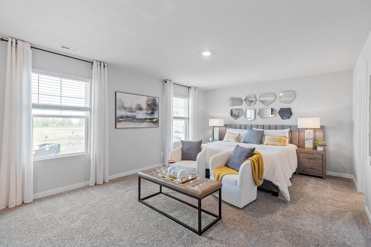 Large primary bedroom showing bathroom and window