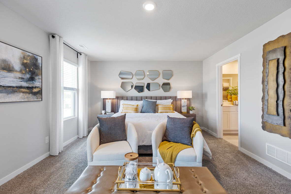 Primary bedroom with two windows and seating area