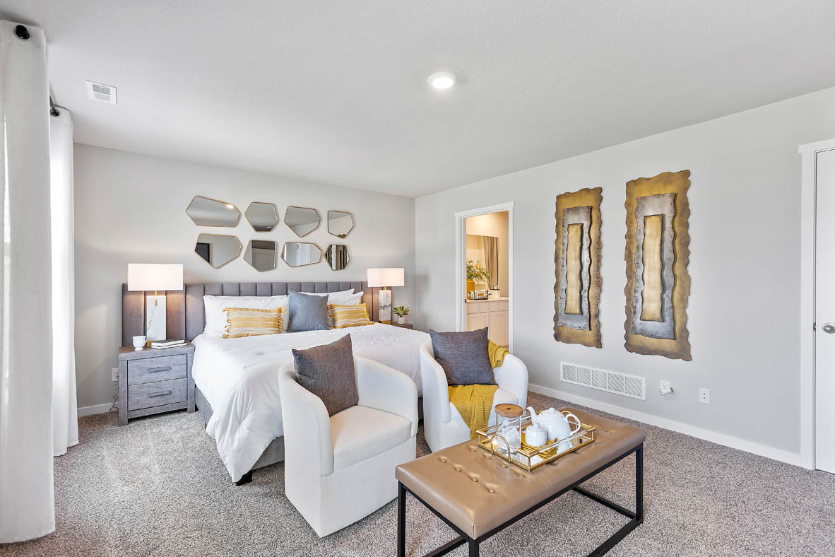 Primary bedroom with chairs and dresser