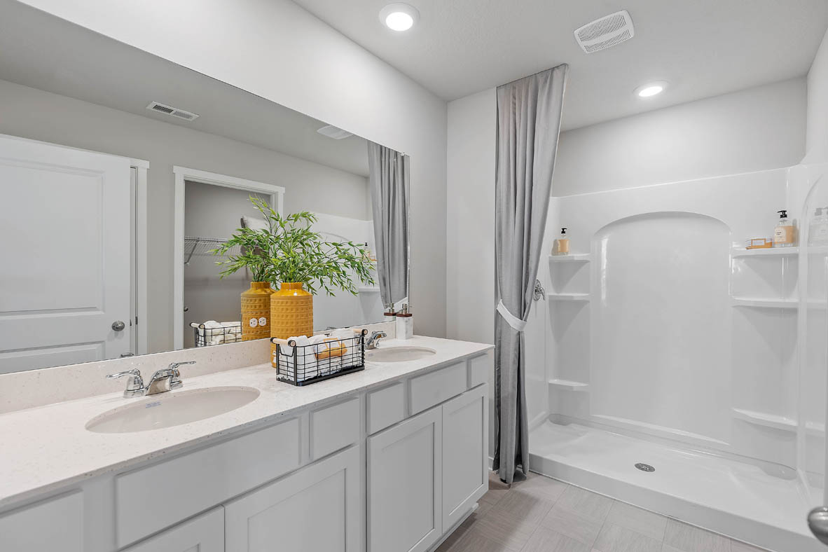 Primary bathroom with walk in shower and dual sinks