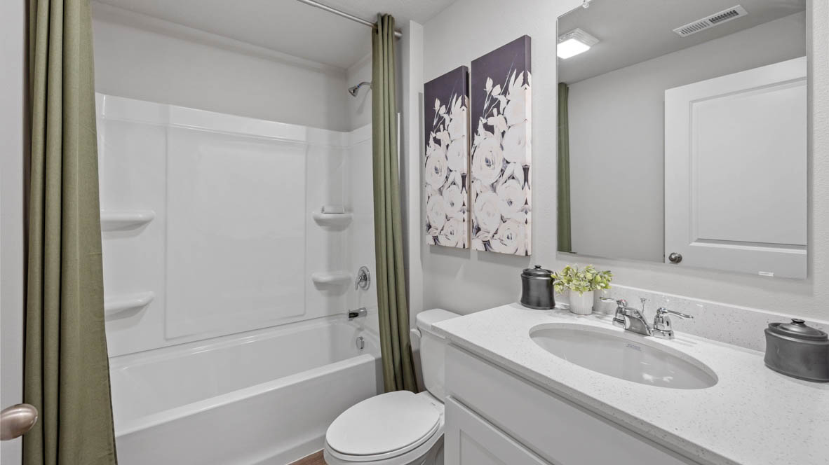 Second bathroom with white cabinets and bathtub