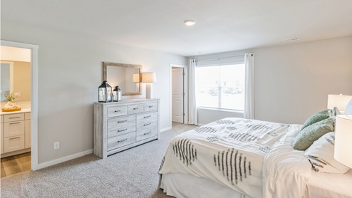 Primary bedroom with large bed and dresser