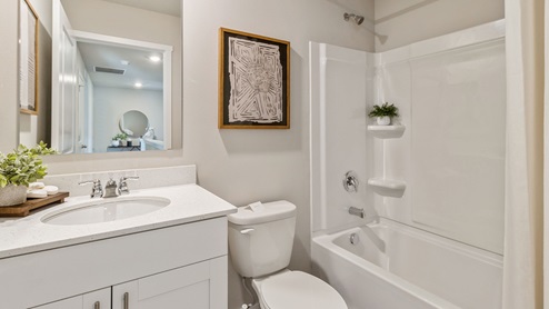 First bathroom with white cabinetry