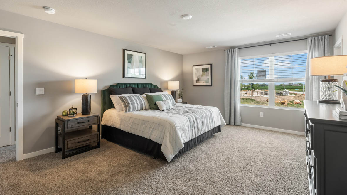 large primary bedroom with carpeting and over-head lighting