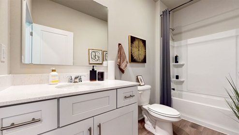 First bathroom with white cabinets