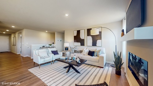 A living room with a couch, side table, and two chairs arranged around a coffee table and sitting atop an area rug.