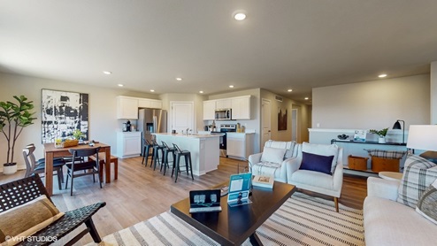 View of a home's entertaining space, comprised of the living and dining spaces and the kitchen.