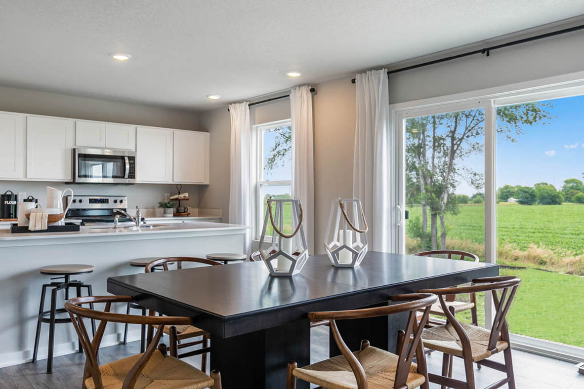 Dining area boasting a table with 6 chairs that provides access to the back yard through sliding doors.