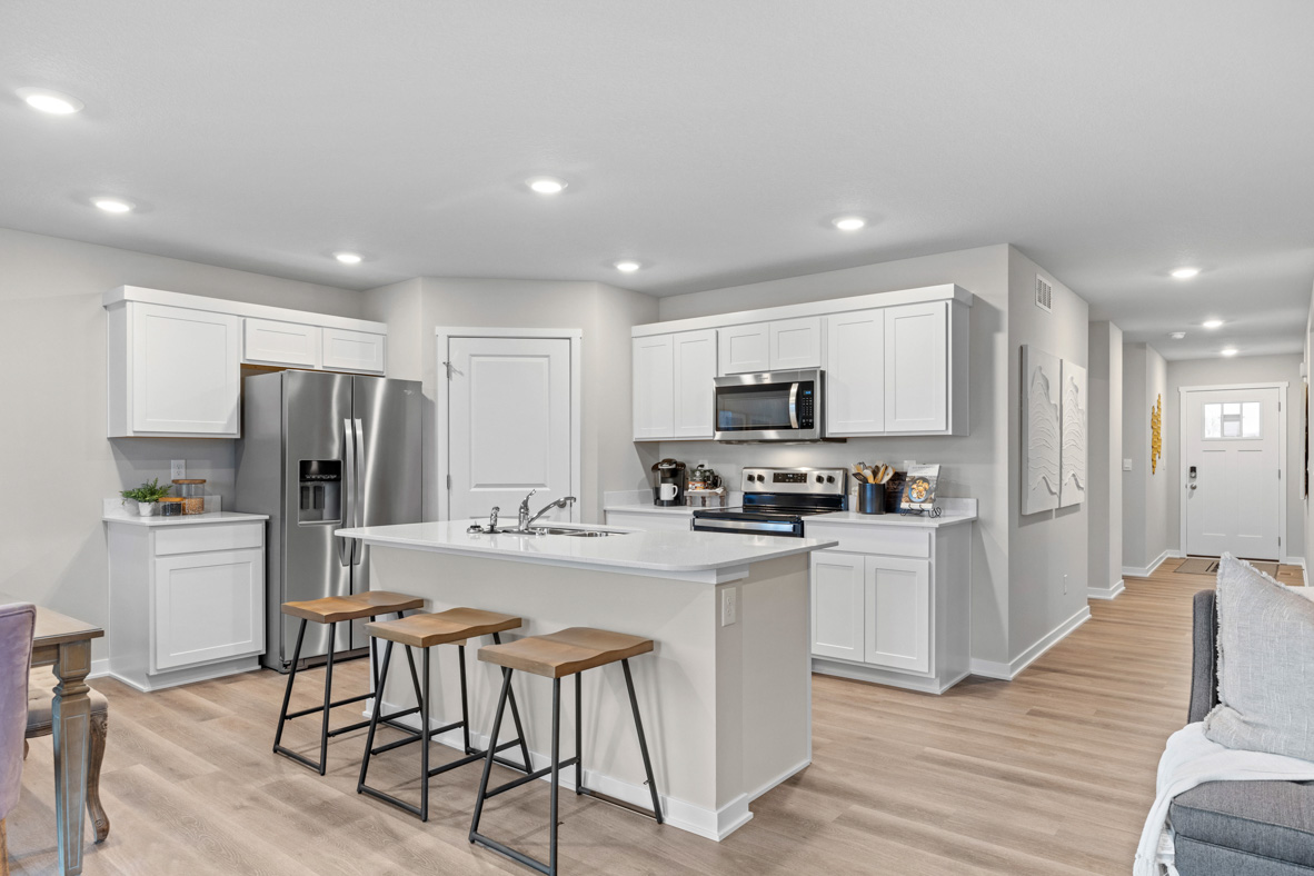 The kitchen in the Harmony plan with white, shaker-style cabinets and stainless-steel appliances.