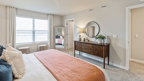 Primary bedroom with wood tv table and two mirrors