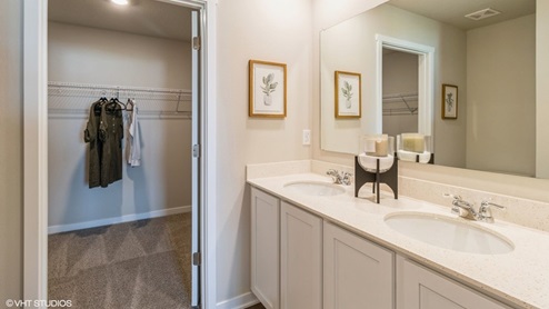 Primary bathroom of the Hamiltons with dual sink and walk in closet