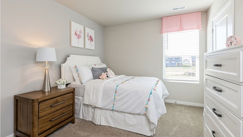 Second bedroom with white bed and a dresser