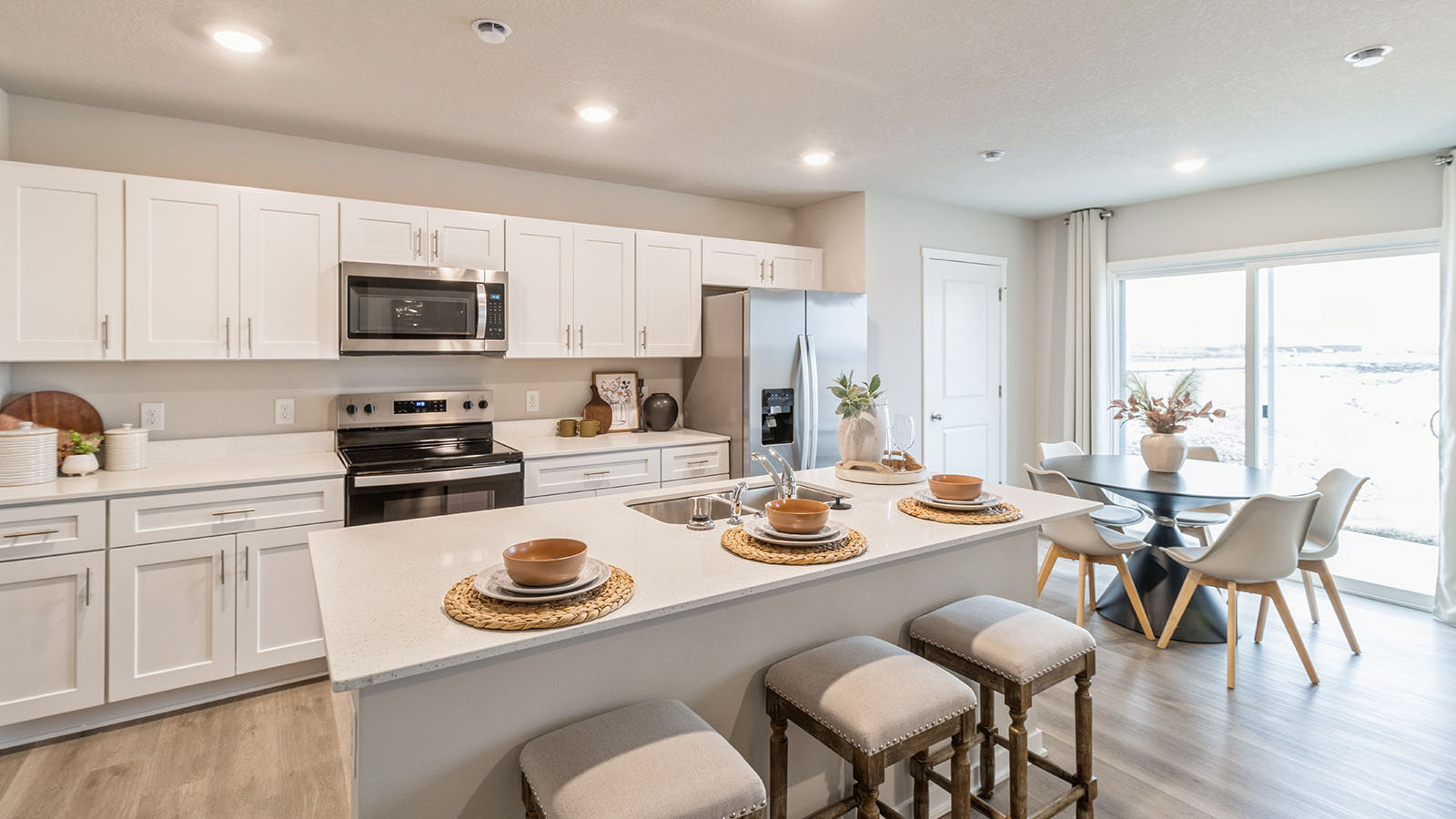 Modern kitchen and dining area with white cabinets and island