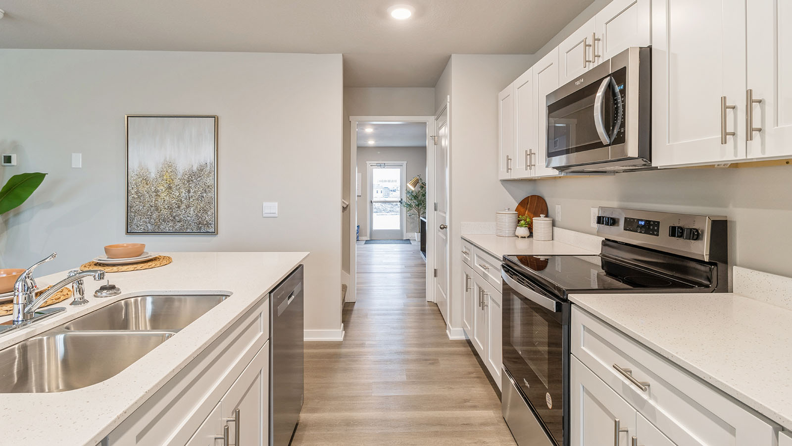 Side view of kitchen with dual sinks on the island and white cabinetry