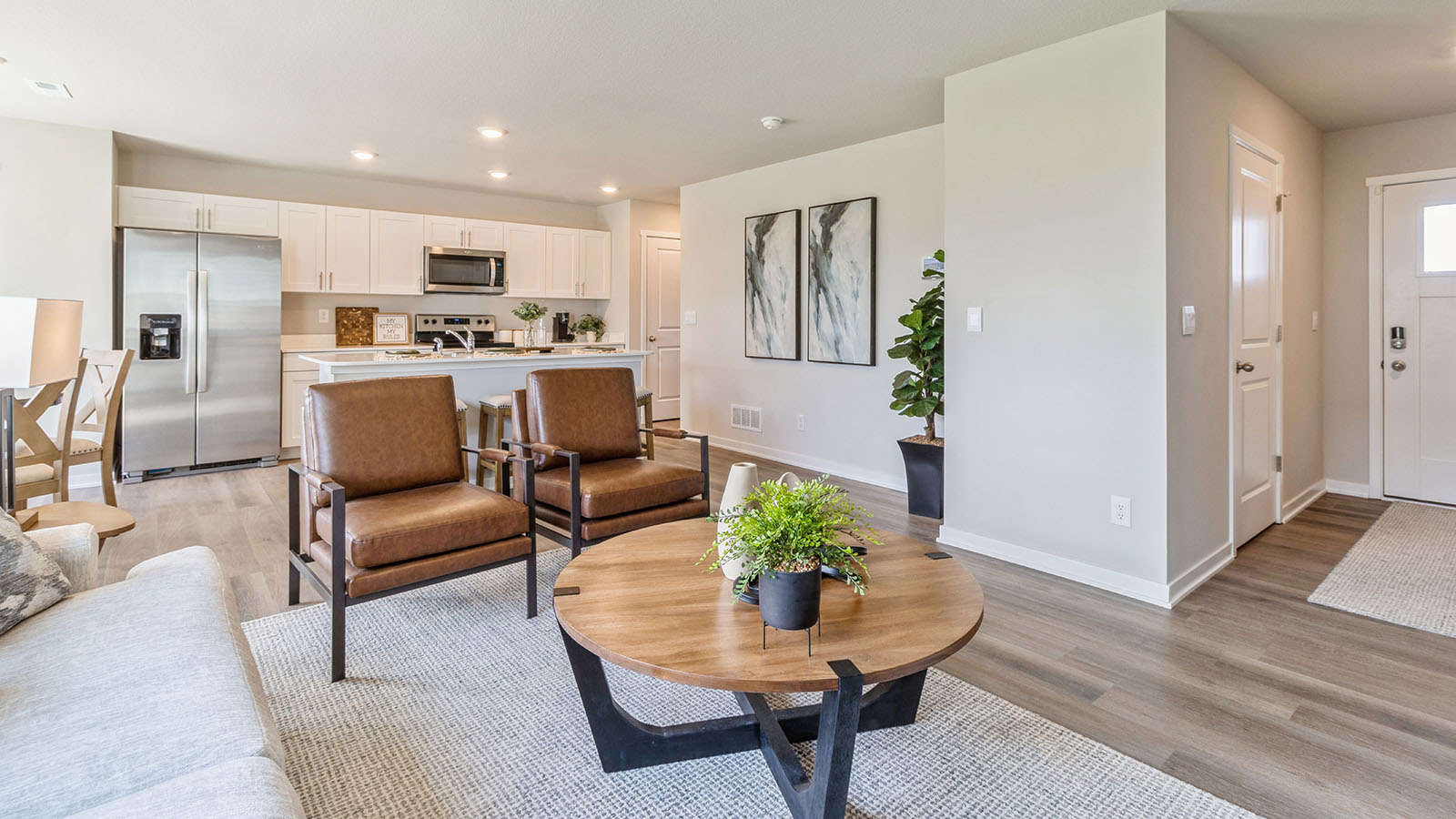 Living room with wood coffee table and two brown chairs next to front door