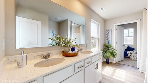 Primary bathroom with large mirror and two sinks