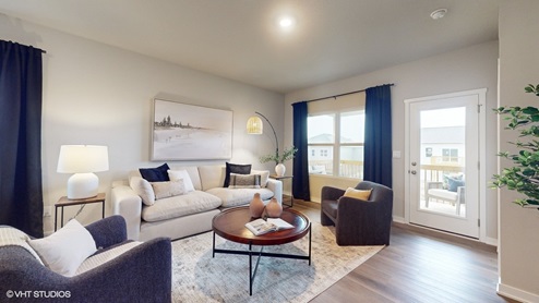 Living room with window and sliding glass doors to balcony
