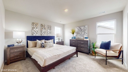 Primary bedroom with two windows and overhead lighting
