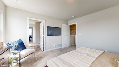 Primary bedroom with chair and tv