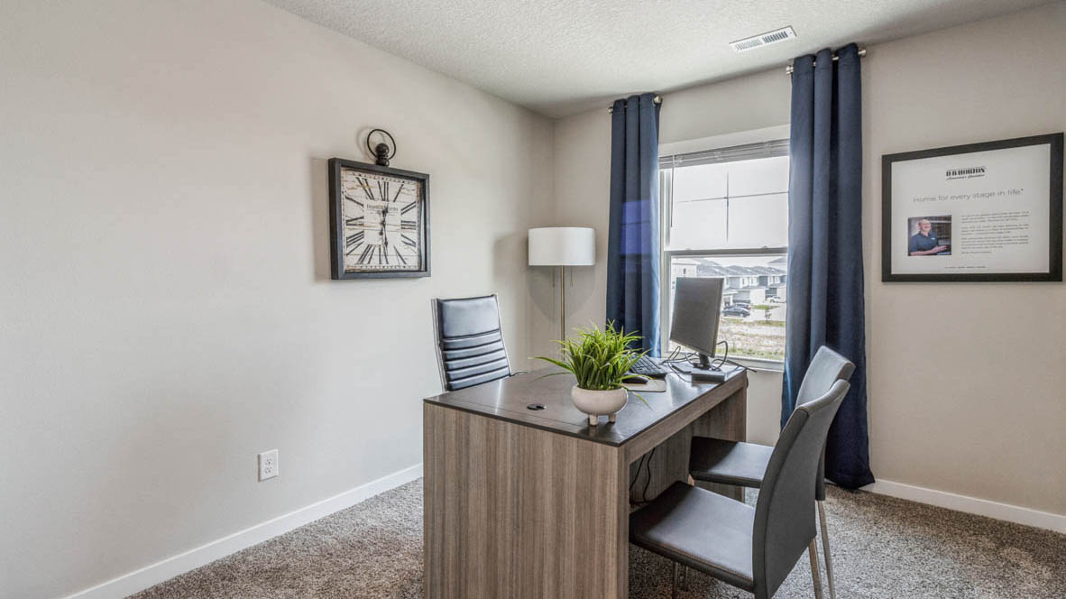Second bedroom staged as office with desk and chairs
