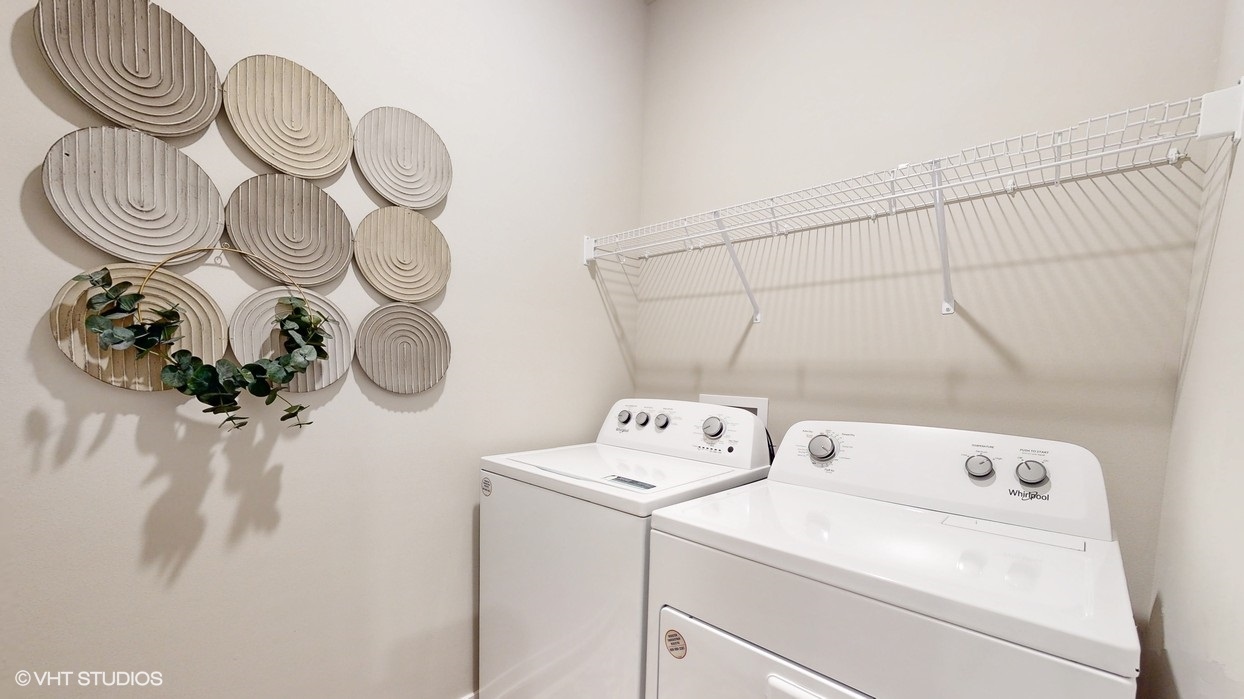 Washer and dryer inside laundry room with shelving