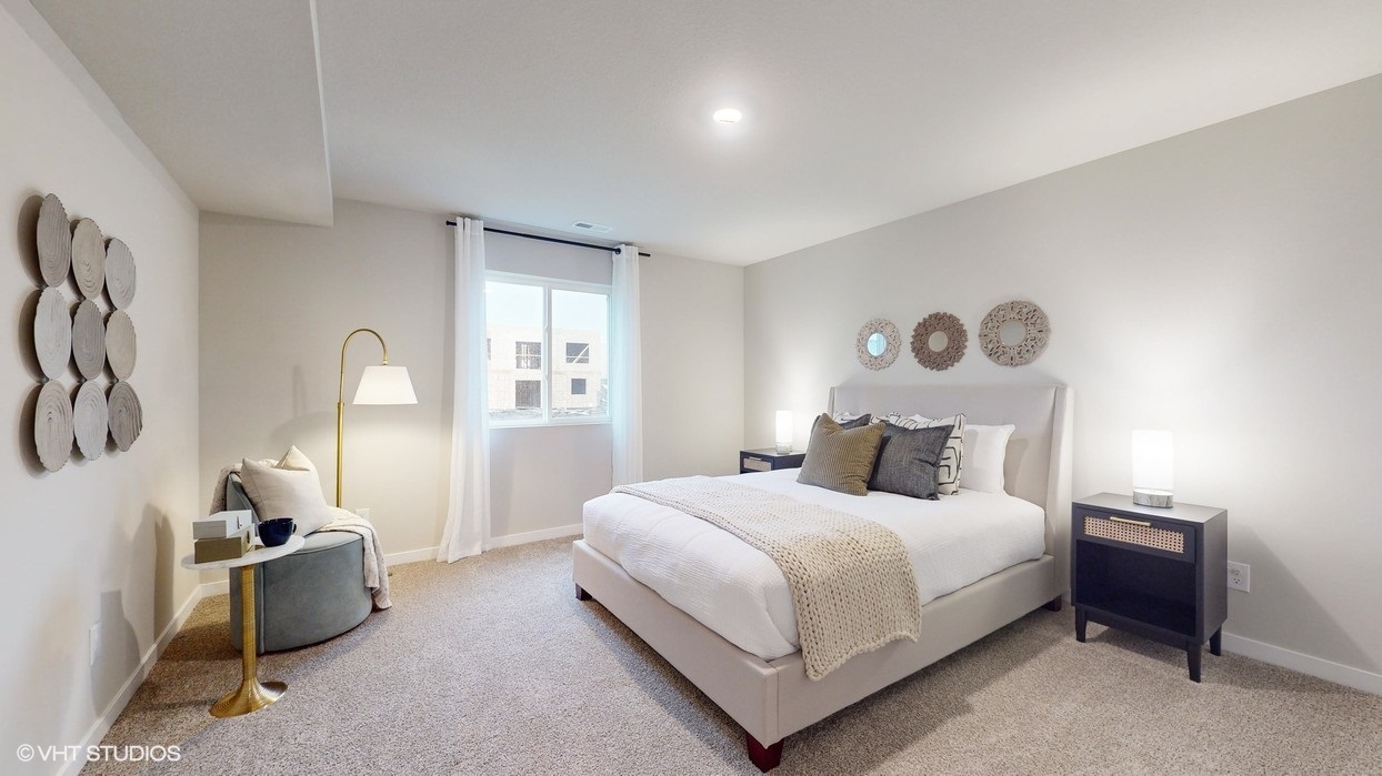 Second bedroom in basement with white bed