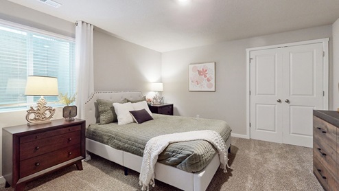 First bedroom with colorful bed and desk with chair