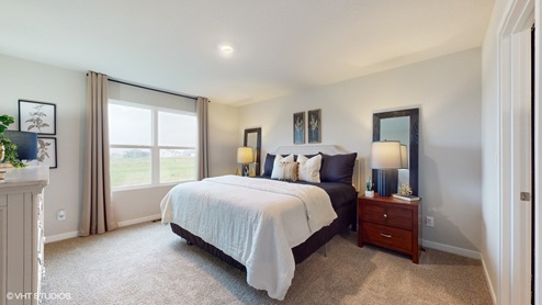 Primary bedroom with large window and white bed