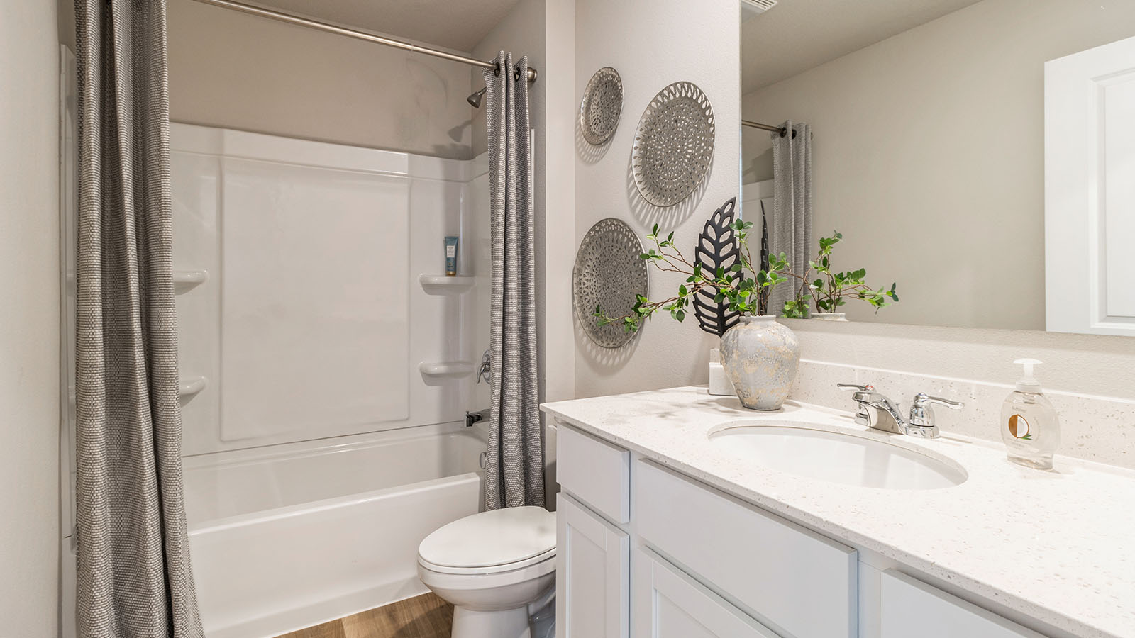 First bathroom with large mirror and shower and bathtub