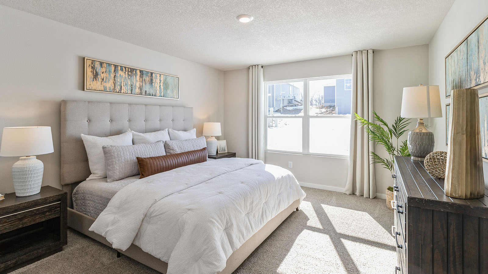 Primary bedroom with large white bed and large window